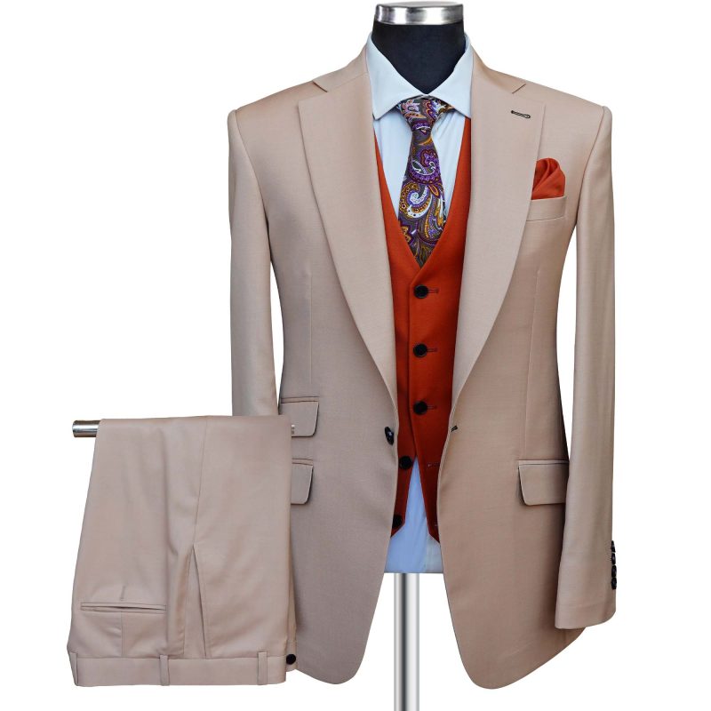 Stylish men's beige suit with orange vest, purple tie, and matching trousers displayed on a mannequin